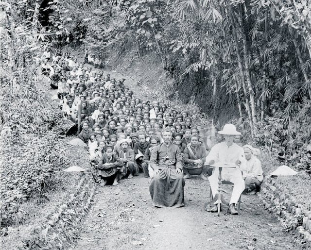 Koloniaal ambtenaar met inlandse bestuurder en arbeiders, ca. 1900