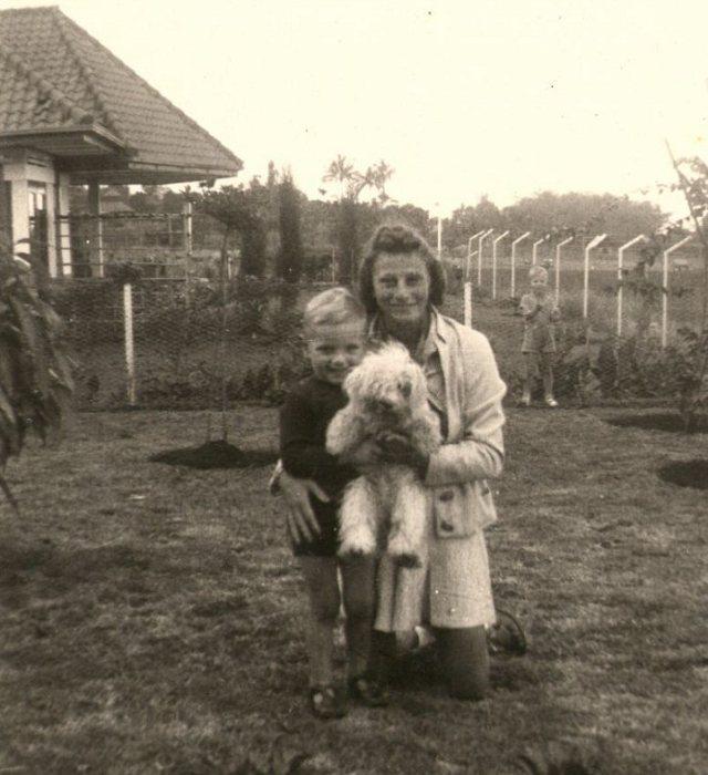 Vrouw met kind en hond in de tuin