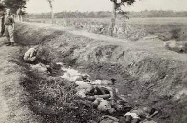Foto (detail) uit album van Jacobus Ridderhof, waarop gedode Indonesiërs in greppel. De heer Nouwen meent zichzelf te herkennen in de hurkende persoon, linksboven. 