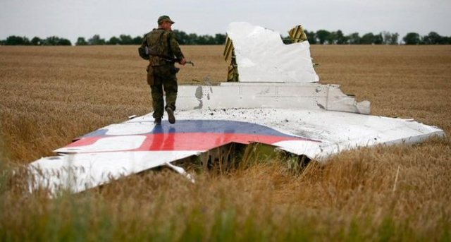 Oekraïns militair loopt over het staartvlak van de MH17