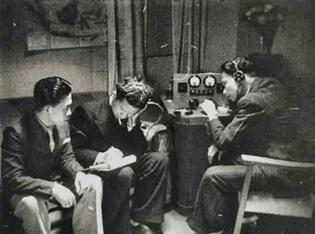 Een scene uit de film Indonesia Calling van Joris Ivens, waarin Indonesische zeelieden naar een kortegolf radio luisteren.