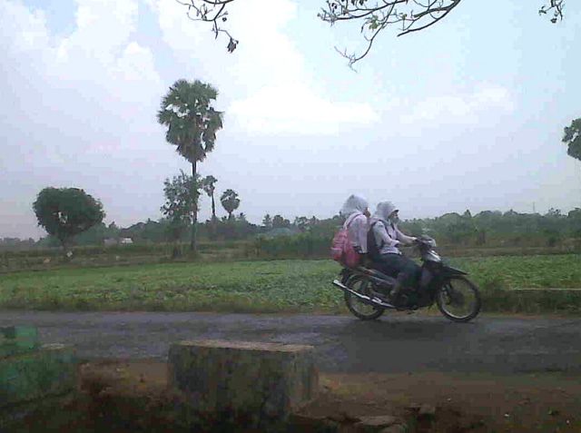 Vrouwen op een brommer in de desa Manjalling, Celebes/Sulawesi